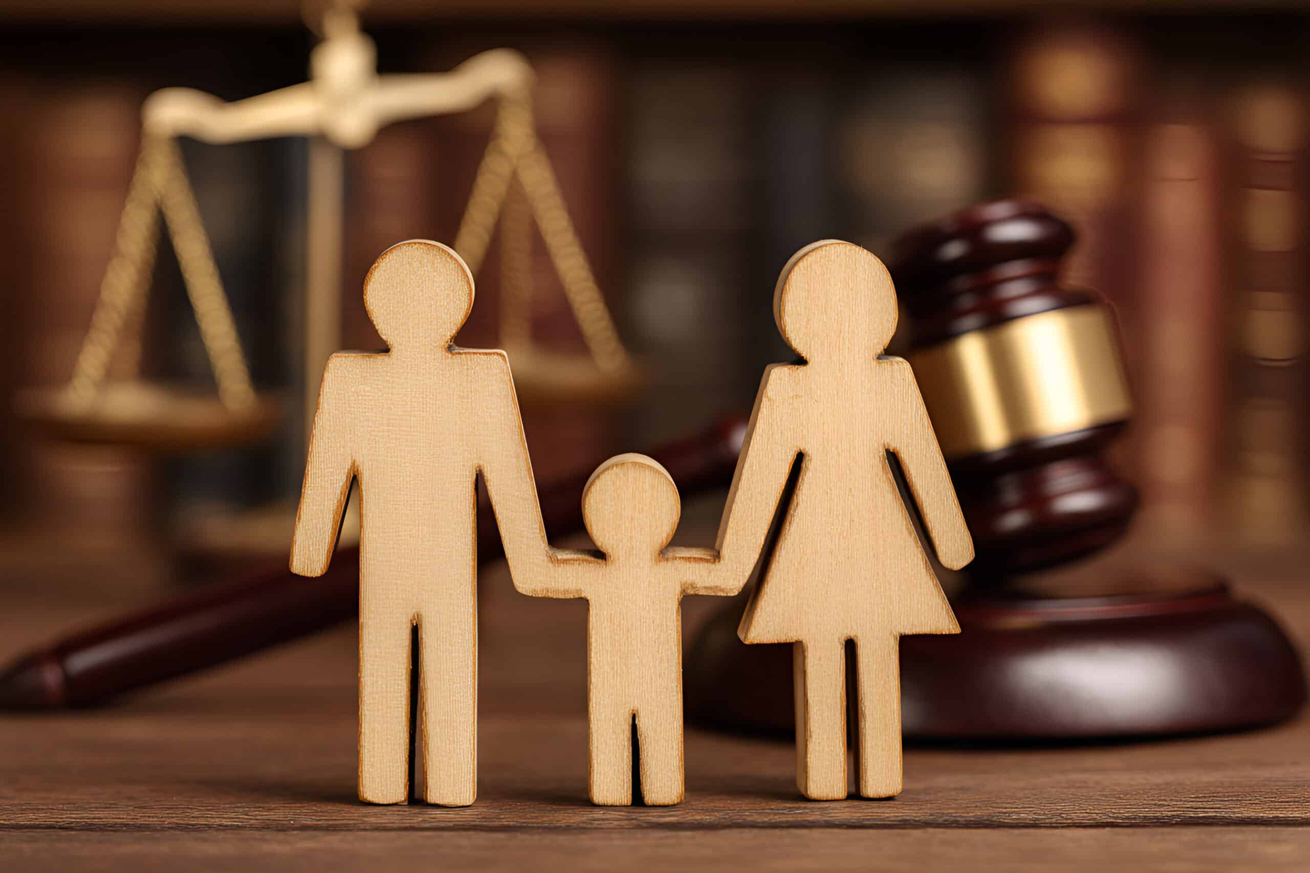 Wooden family in front of judges gavel present for a Family Law Procedure.
